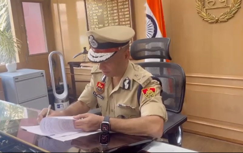 O. P. Singh signing files at his desk, in Director General of Police uniform